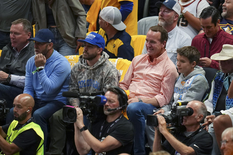 Peyton Manning, center right, watches during the first half of Game 1 of basketball's NBA Finals between the Denver Nuggets and the Miami Heat, Thursday, June 1, 2023, in Denver. (AP Photo/Jack Dempsey)