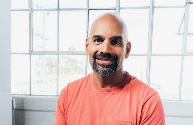 Naveen Rao smiling in front of a window.