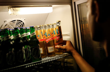 A waiter takes a bottle of Kingfisher beer out of a fridge at a pub in Mumbai, India, October 20, 2018. REUTERS/Danish Siddiqui