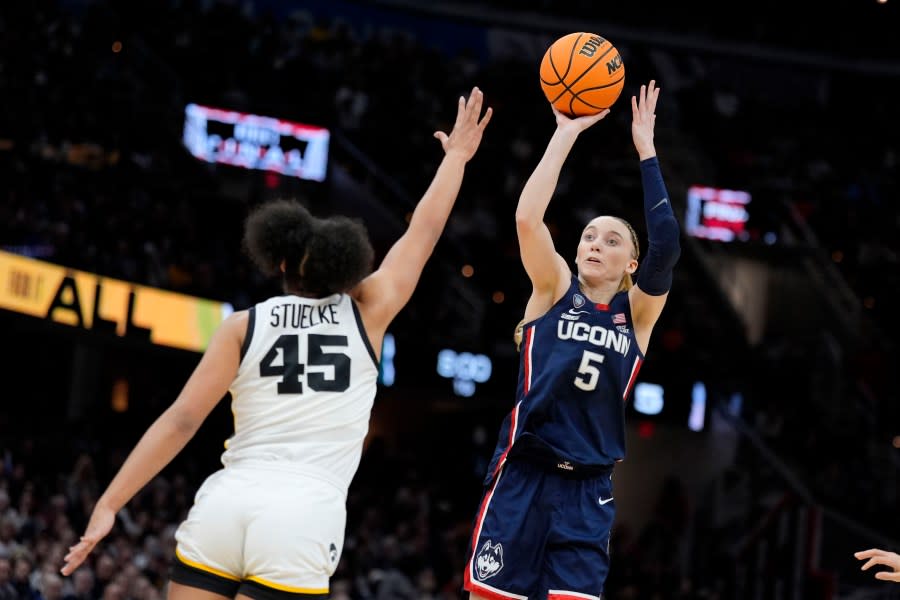 UConn guard Paige Bueckers (5) shoots over Iowa forward <a class="link " href="https://sports.yahoo.com/ncaaw/players/70737/" data-i13n="sec:content-canvas;subsec:anchor_text;elm:context_link" data-ylk="slk:Hannah Stuelke;sec:content-canvas;subsec:anchor_text;elm:context_link;itc:0">Hannah Stuelke</a> (45) during the first half of a Final Four college basketball game in the women’s NCAA Tournament, Friday, April 5, 2024, in Cleveland. (AP Photo/Morry Gash)