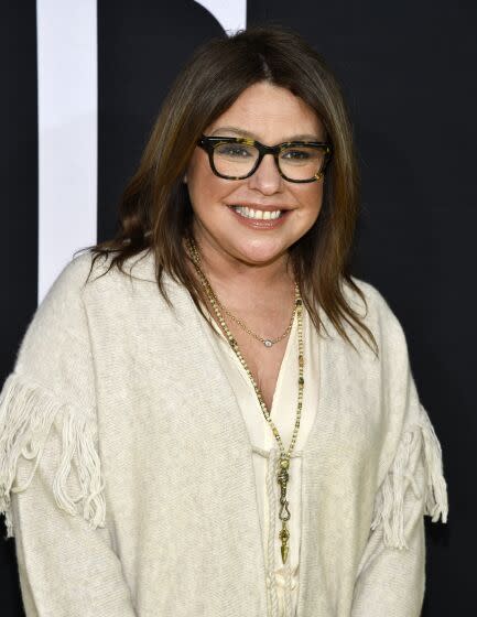 Rachael Ray in thick black glasses and a white tunic