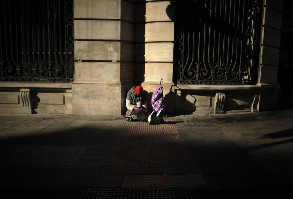 <em>Un pobre es fotografiado el domingo en una calle de Madrid. (AFP | Pedro Armestre)</em>