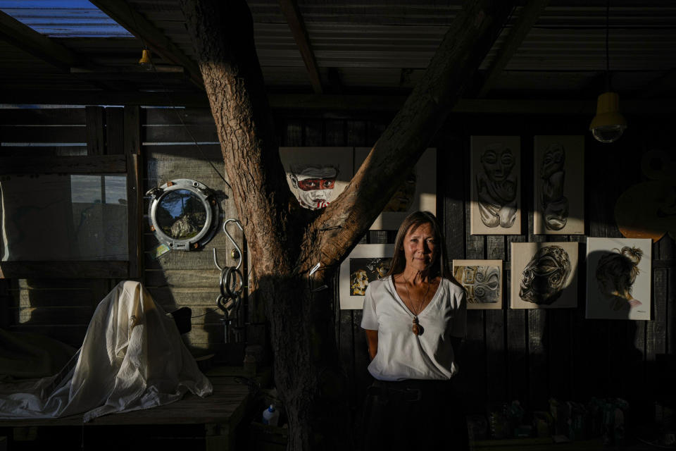 French-born artist Delphine Poulain poses for a portrait inside her home studio in Hanga Roa, Rapa Nui, or Easter Island, Chile, Wednesday, Nov. 23, 2022. Poulain says she treasures the freedom and the tranquility provided by the remoteness of the island, home to about 7,700 people. (AP Photo/Esteban Felix)