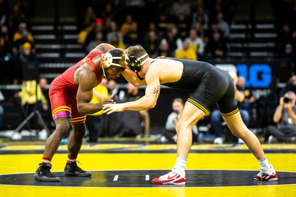 Iowa State's Paniro Johnson, left, wrestles Iowa's Max Murin on Dec. 4, 2022, at Carver-Hawkeye Arena in Iowa City.