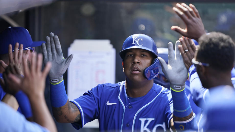 Kansas City Royals' Salvador Perez is congratulated by teammates after hitting a solo home run off Cleveland Indians starting pitcher Shane Bieber in the fourth inning of a baseball game against the Cleveland Indians, Wednesday, April 7, 2021, in Cleveland. (AP Photo/Tony Dejak)