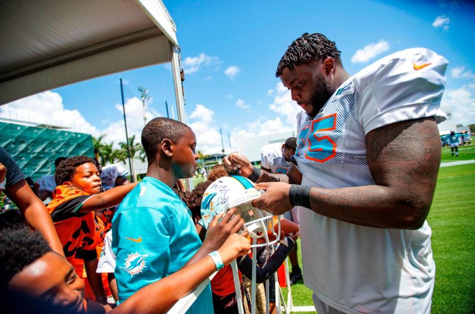 Miami Dolphins offensive tackle Greg Little (75) signing autographs to fans after NFL football training camp at Baptist Health Training Complex in Hard Rock Stadium on Friday, August 5, 2022 in Miami Gardens, Florida.