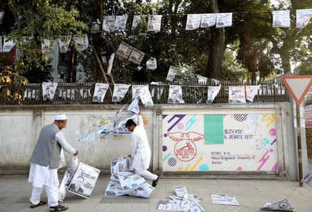 People hang posters of an election candidate ahead of the 11th general election in Dhaka, Bangladesh, December 28, 2018. REUTERS/Mohammad Ponir Hossain