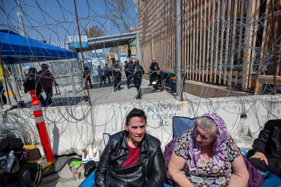 Two Ukrainian women sit and wait for U.S. Customs and Border Protection to allow them to enter the U.S. at the San Ysidro Port of Entry in Tijuana, Baja California on Tuesday.