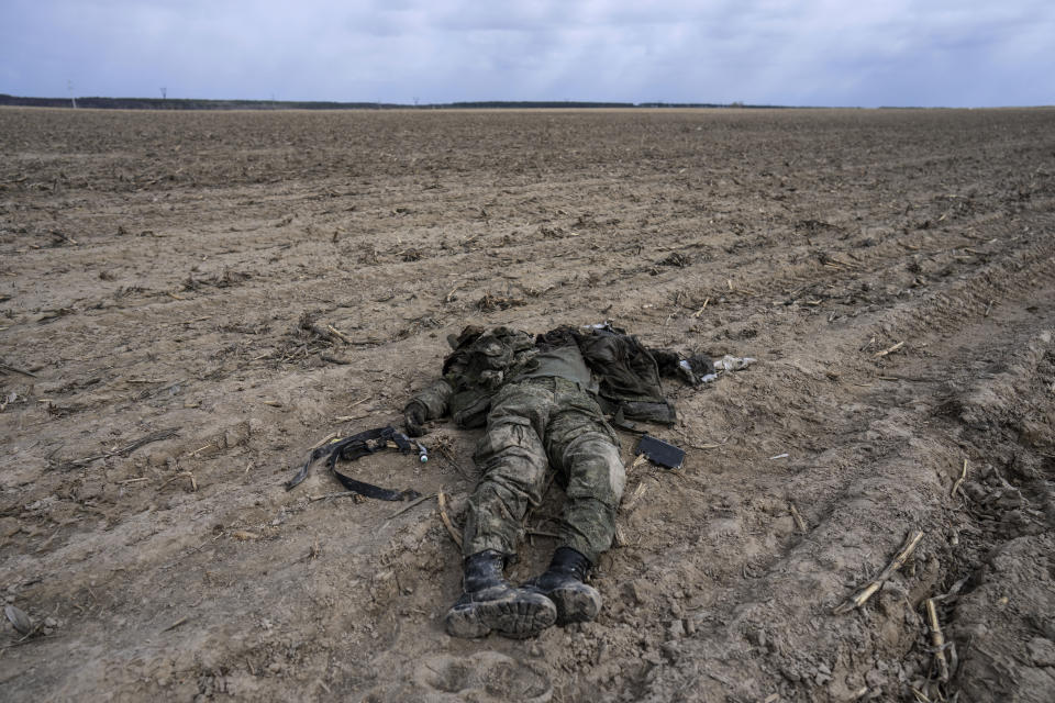 FILE - A Russian soldier killed during combats against Ukrainian army lies on a corn field in Sytnyaky, on the outskirts of Kyiv, Ukraine, Sunday, March 27, 2022. Quantifying the toll of Russia’s war in Ukraine remains an elusive goal a year into the conflict. Estimates of the casualties, refugees and economic fallout from the war produce an complete picture of the deaths and suffering. Precise figures may never emerge for some of the categories international organizations are attempting to track. (AP Photo/Rodrigo Abd, File)
