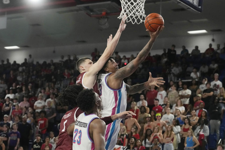 Florida Atlantic guard Brandon Weatherspoon (23) aims the ball as Charleston forward Ante Brzovic (10) defends during the first half of an NCAA college basketball game, Saturday, Dec. 2, 2023, in Boca Raton, Fla. (AP Photo/Marta Lavandier)