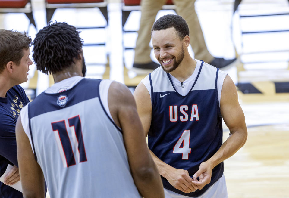 Stephen Curry, right, of the Golden State Warriors, talks with Joel Embiid (11) of the Philadelphia 76ers during the United States men's basketball team's training camp on Saturday, July 6, 2024, in Las Vegas.  (AP Photo/Steve Marcus)