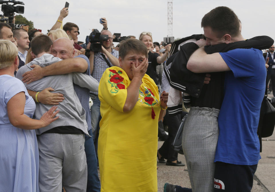 Relatives of Ukrainian prisoners freed by Russia greet them upon their arrival at Boryspil airport, outside Kyiv, Ukraine, Saturday, Sept. 7, 2019. Planes carrying prisoners freed by Russia and Ukraine have landed in the countries' capitals, in an exchange that could be a significant step toward improving relations between Moscow and Kyiv. The planes, each reportedly carrying 35 prisoners, landed almost simultaneously at Vnukovo airport in Moscow and at Kyiv's Boryspil airport. (AP Photo/Efrem Lukatsky)