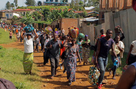 Refugees from the Democratic Republic of Congo carry their belongings as they walk near the the United Nations High Commissioner for Refugees (UNHCR) offices in Kiziba refugee camp in Karongi District, Rwanda February 21, 2018. REUTERS/Jean Bizimana