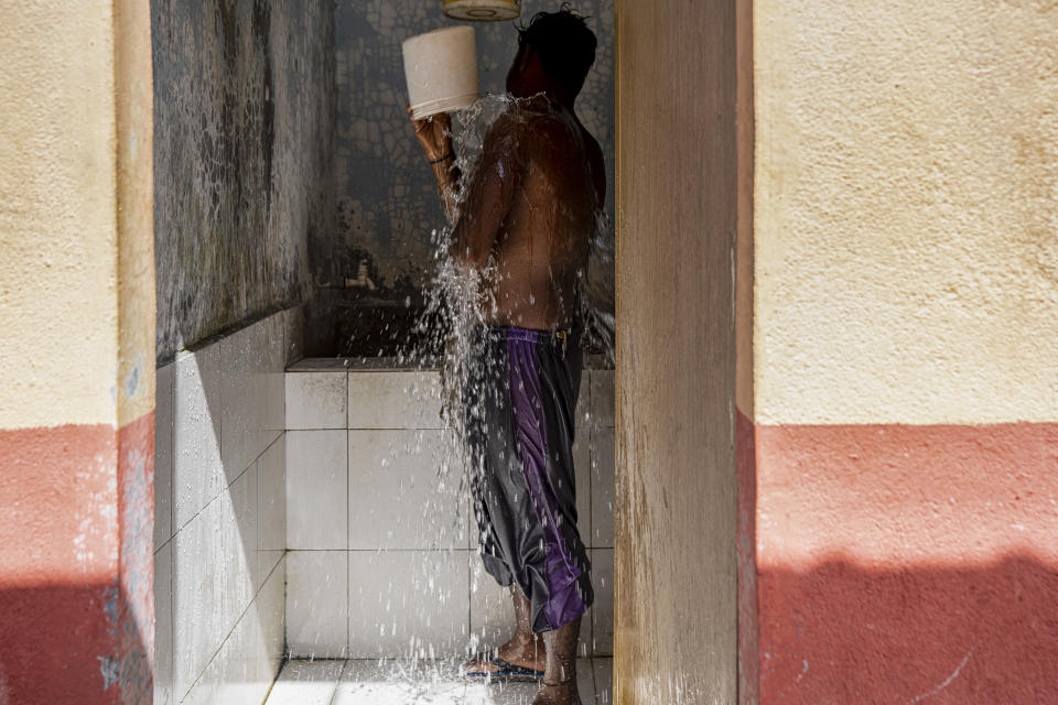 A worker bathes at a palm oil plantation run by government-owned Felda in peninsular Malaysia, in early 2020. Jum, a former worker who escaped from this same plantation, described to The Associated Press how the company confiscated, and later lost, his Indonesian passport, leaving him vulnerable to arrest and forcing him to hide in the jungle. (AP Photo/Ore Huiying)