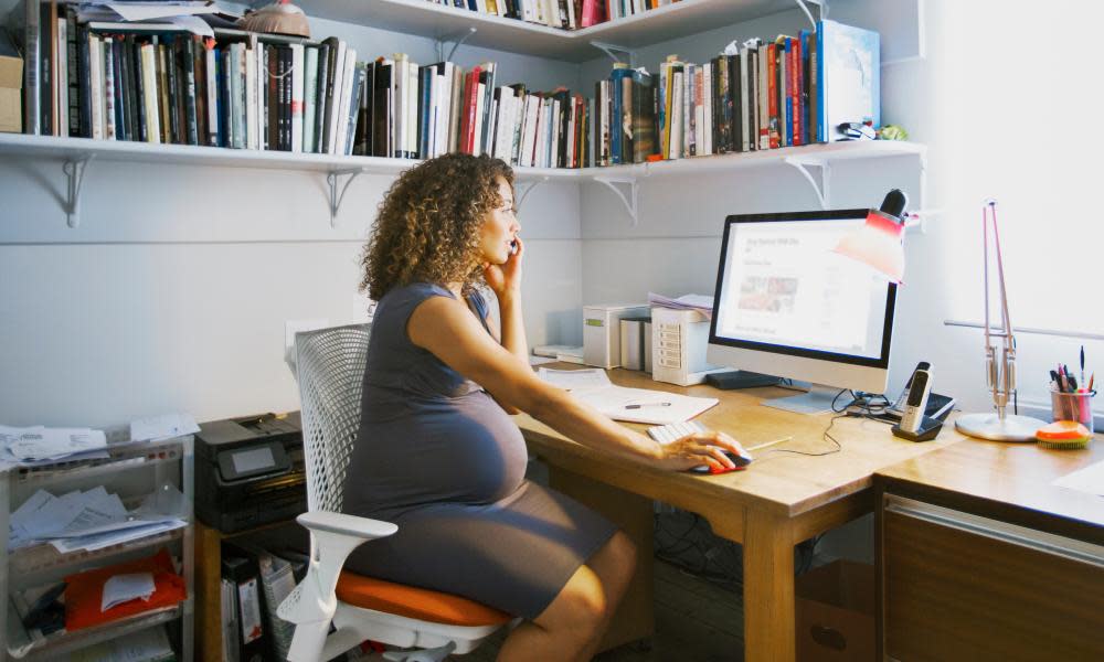 A pregnant woman works from her home office.