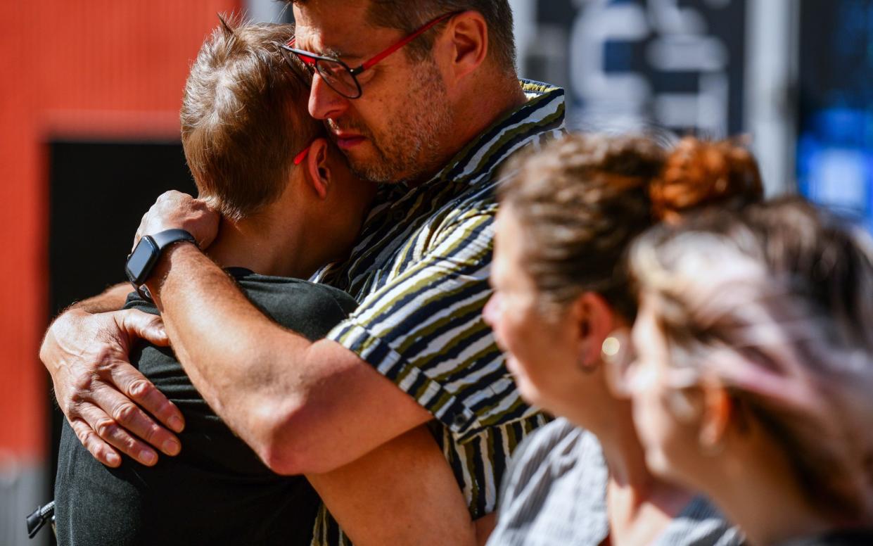 Mourners embrace each other after three people were killed in a knife attack