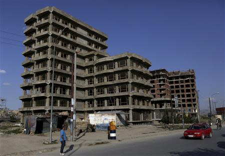 A man walks near a residential complex which is under construction in Kabul May 14, 2014. REUTERS/Omar Sobhani