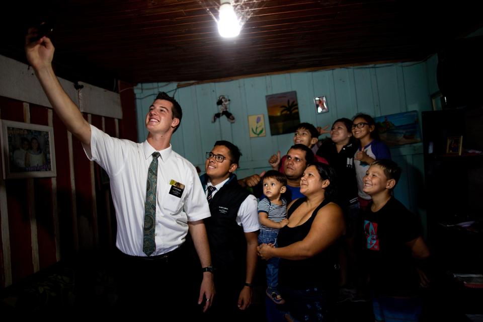 Elders Tanner McKee and Pedro Cabral, missionaries for The Church of Jesus Christ of Latter-day Saints, take a selfie with the Almeida family after teaching a lesson about the church in their home in Paranaguá, Brazil, on Saturday, June 1, 2019. | Spenser Heaps, Deseret News