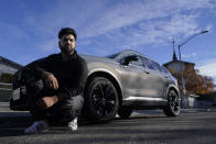 Shalinder Singh poses for photos in front of a 2024 Honda CR-V Hybrid in Sunnyvale, Calif., Monday, Dec. 11, 2023. Like many hybrid buyers, Singh, an Uber driver, said that for him, the gas savings helped tip the price equation in favor of a Honda CR-V hybrid over the corresponding gasoline model. (AP Photo/Jeff Chiu)