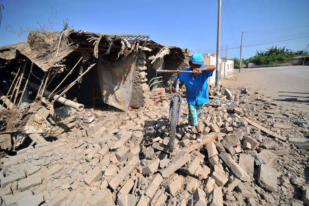 A man passes the debris of a building after a strong magnitude 7.1 earthquake struck the coast of southern Peru, in Acari, Arequipa , Peru, January 14, 2018. REUTERS/Diego Ramos