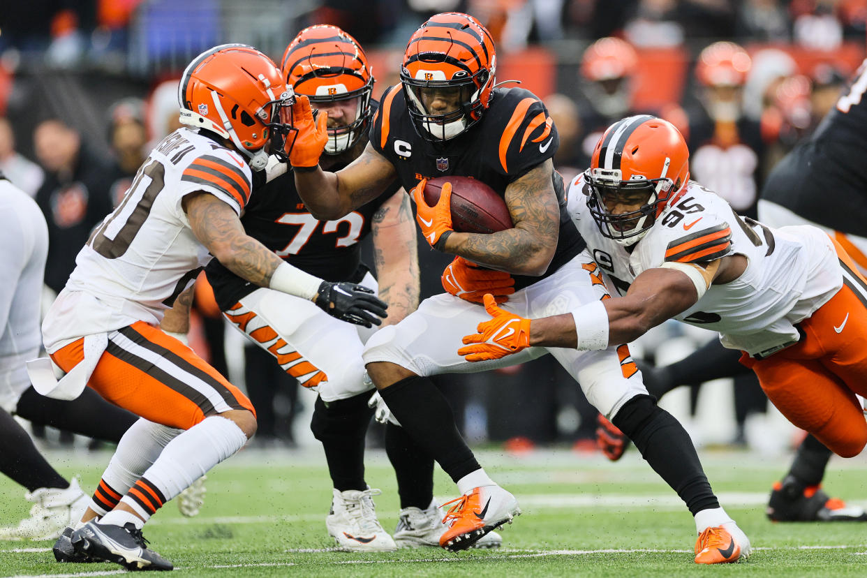 CINCINNATI, OHIO - DECEMBER 11: Joe Mixon #28 of the Cincinnati Bengals runs with the ball as Myles Garrett #95 of the Cleveland Browns looks to make a tackle in the second half at Paycor Stadium on December 11, 2022 in Cincinnati, Ohio. (Photo by Andy Lyons/Getty Images)