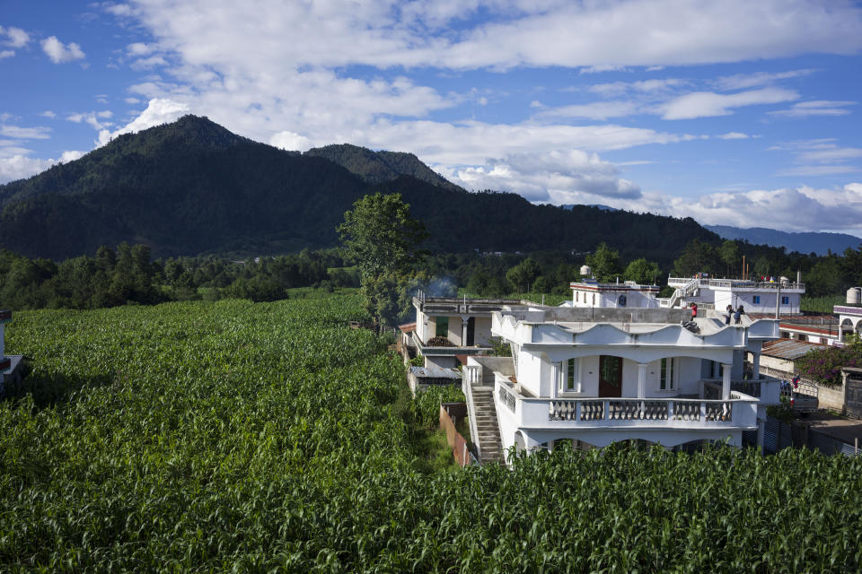 A house built by migrants is surrounded by corn fields, in Tzucubal, Guatemala, Wednesday, June 29, 2022, the hometown of Pascual Melvin Guachiac and Wilmer Tulul, both 13, who were among the dead discovered inside a tractor-trailer near auto salvage yards on the edge of San Antonio, Texas, on Monday, in what is believed to be the nation's deadliest smuggling episode on the U.S.-Mexico border. (AP Photo/Moises Castillo)