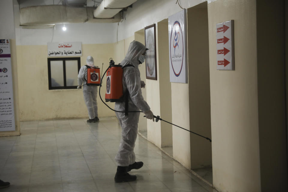 Members of a humanitarian aid agency disinfect Ibn Sina hospital as prevention against coronavirus in the city of Idlib, Syria, Thursday, March 19, 2020. (AP Photo/Ghaith Alsayed)