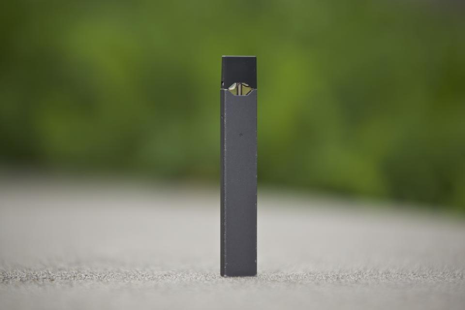 FILE - This April 16, 2019, file photo, shows a Juul vape pen in Vancouver, Wash. New research released on Tuesday, Nov. 5, 2019, shows U.S. teens who use electronic cigarettes prefer those made by Juul Labs, and mint is the favorite flavor for many of them, suggesting a shift after the company stopped selling fruit and dessert flavors in stores. (AP Photo/Craig Mitchelldyer, File)