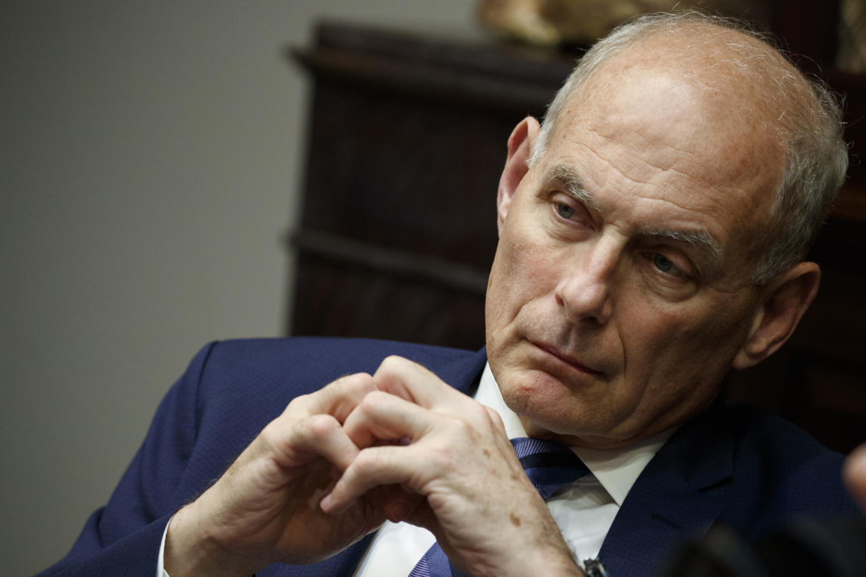 John Kelly, White House chief of staff at the time, listens intently, hands clasped.
