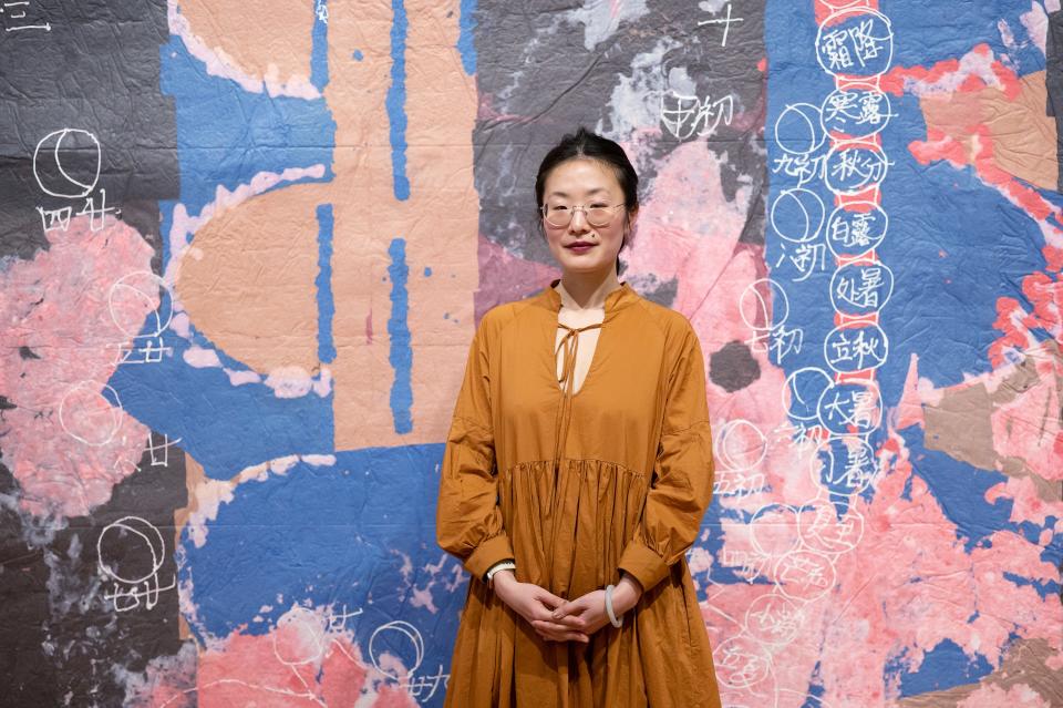 Hong Hong poses in front of her piece, Diagram of a Cosmic Being II 2022, currently on display as part of "Paper Town" at Fitchburg Art Museum on Sunday April 02, 2023.