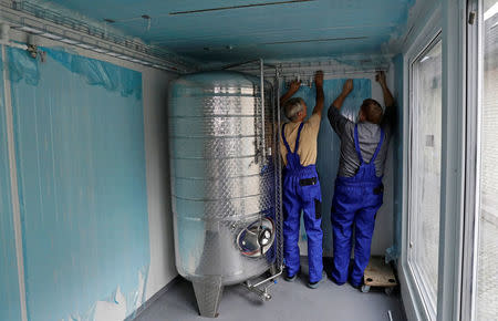 Workers of Smart Brewery Well Service set up pipes inside of a standard shipping container in the village of Chlum near the town of Trebic, Czech Republic, September 2, 2017. Picture taken September 2, 2017. REUTERS/David W Cerny