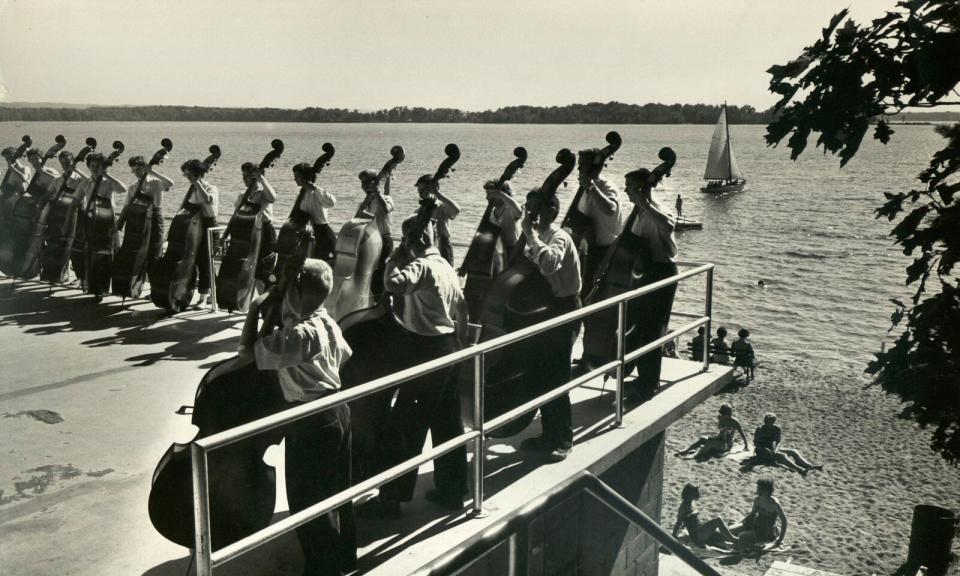 Campers line up on the shore of Lake Wahbekanetta at the National Music Camp in Interlochen, Michigan, for instruction from Oscar Zimmerman, former first bass player for Toscanini.  