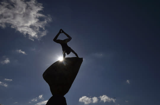 <p>A gymnast poses on top of stones at a garden display at the Chelsea Flower Show in London on May 23, 2016. (Toby Melville/Reuters) </p>