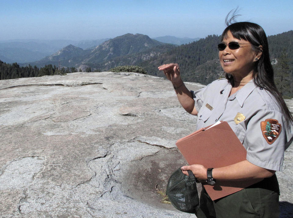 In this May 11, 2012 photo, Sequoia National Park air resource specialist Annie Esperanza explains how ozone diminishes the view from Beetle Rock in Sequoia National Park, Calif. A big city problem has settled in a big way in Sequoia Kings Canyon National Park, home of the giant Sequoias. Smog from the neighboring Central Valley is making it tougher for seedlings from the giants to take hold, and the needles of surrounding Jeffrey and Ponderosa pines are yellowing. (AP Photo/Tracie Cone)