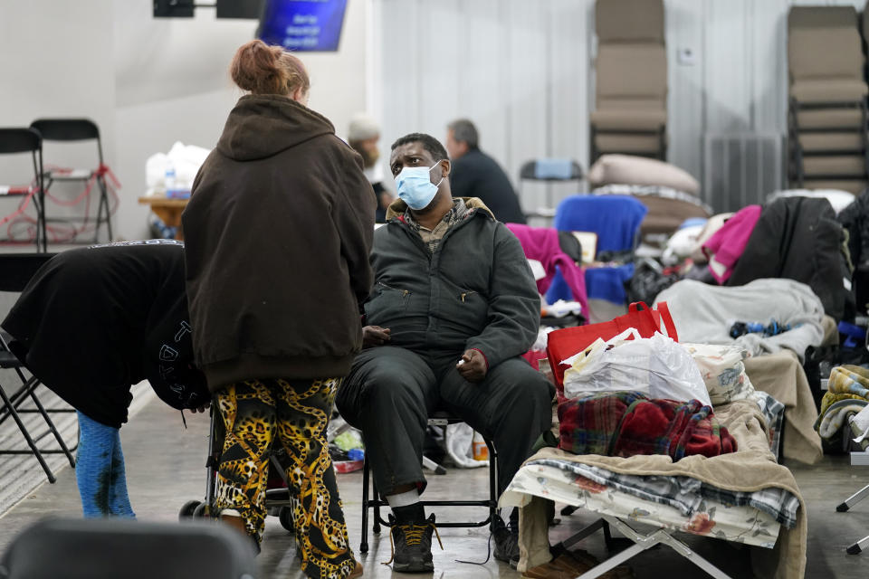 Tommy Lynn Jackson, right, who was displaced from his destroyed home, talks with others inside a shelter for victims, in the aftermath of tornadoes that tore through the region, in Wingo, Ky., Tuesday, Dec. 14, 2021. (AP Photo/Gerald Herbert)
