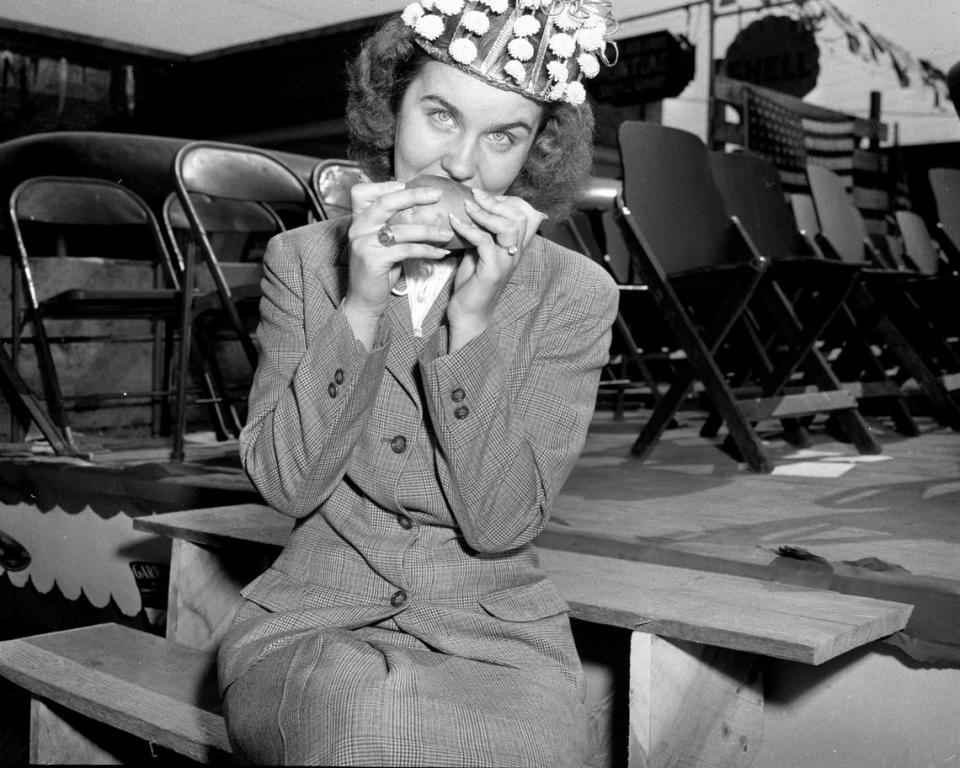 The Sweet Potato Queen bites into one of the yams for a photographer at “Tater Day” in Tabor City, NC. October 31, 1947.