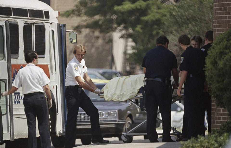 FILE - In this Aug. 20, 1986, file photo, members of the Edmond, Okla., police department and medical personnel remove the body of one of the people killed in a shooting spree at the post office in Edmond. Mass workplace killings have been happening for decades in the U.S. and around the world, gaining widespread attention in the 1980s and ‘90s, with this being one of the deadliest. (AP Photo/Steve Gooch, File)