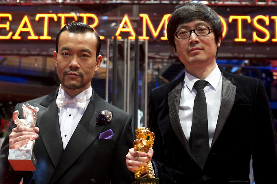 Actor Liao Fan, left, with the Silver Bear for Best Actor and director Diao Yinan with the Golden Bear for Best Film for the movie Black Coal, Thin Ice pose for photographers after the award ceremony at the International Film Festival Berlinale in Berlin, Saturday, Feb. 15, 2014. (AP Photo/Axel Schmidt)