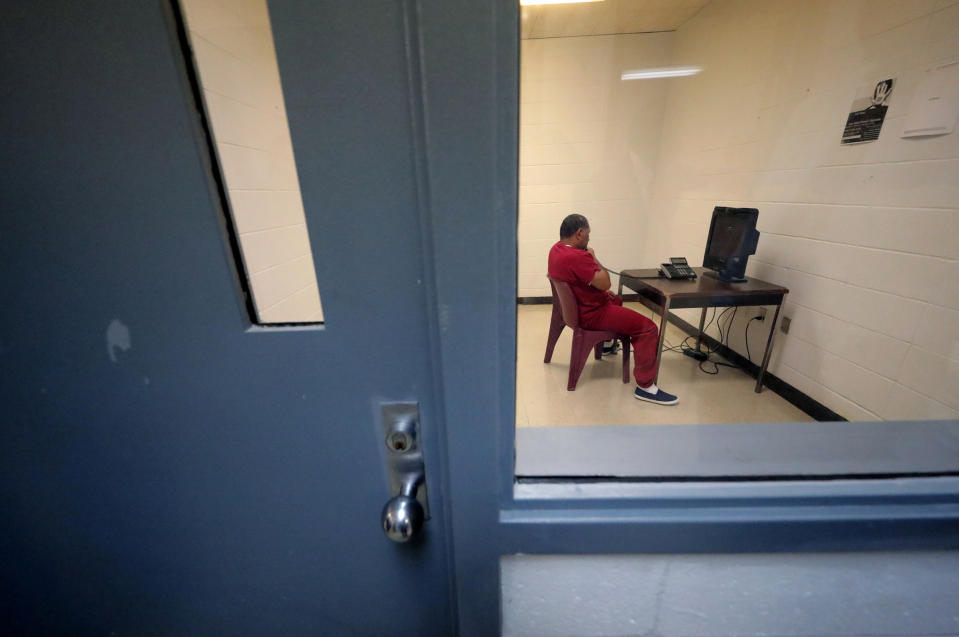A detainee sits in a room to use a telephone inside the Winn Correctional Center in Winnfield, La., on  Sept. 26, 2019. (Gerald Herbert / AP file)