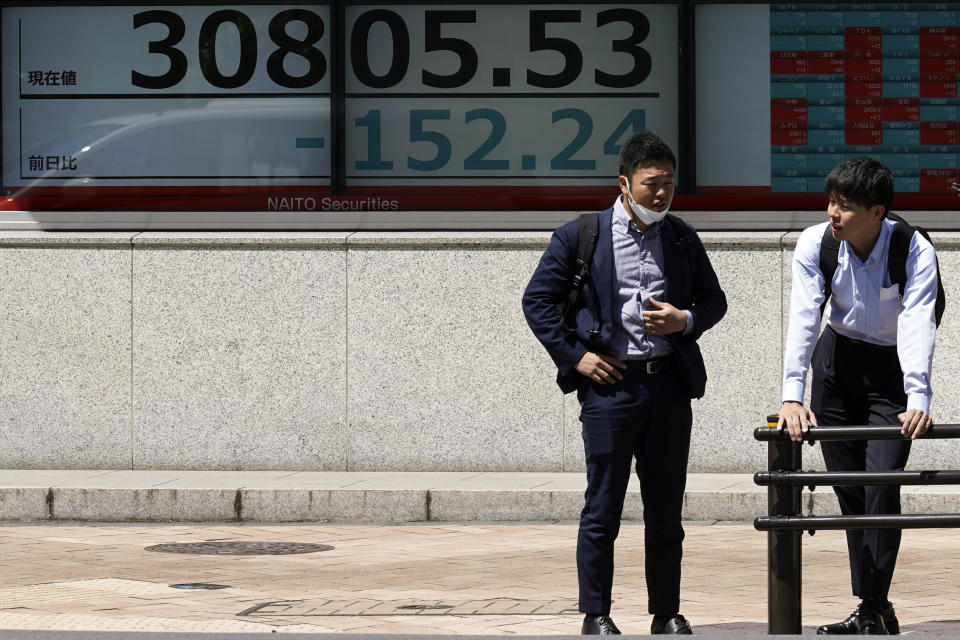 People stand in front of an electronic stock board showing Japan's Nikkei 225 index at a securities firm Wednesday, May 24, 2023, in Tokyo. Asian stock markets slid Wednesday as the U.S. government crept closer to a potentially disruptive default on its debt. (AP Photo/Eugene Hoshiko)