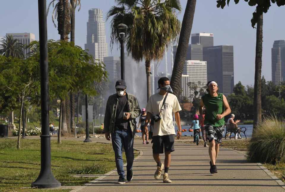 People utilize the Echo Park Lake recreation area Saturday, May 23, 2020, in Los Angeles during the coronavirus pandemic. California Gov. Gavin Newsom has approved 45 of California's 58 counties to reopen some businesses since May 8 when he loosened his original mid-March stay-at-home order. (AP Photo/Mark J. Terrill)