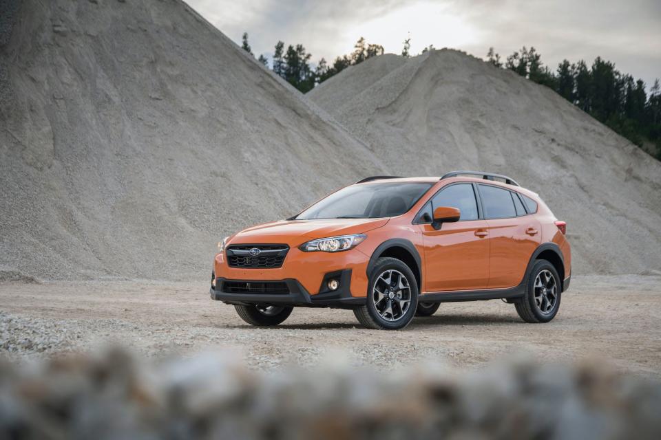 An orange 2020 Subaru Crosstrek Premium next to gray hills.