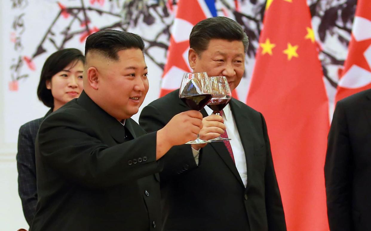 North Korean leader Kim Jong Un (L) and Chinese President Xi Jinping (R) making a toast at the Great Hall of the People in Beijing - AFP