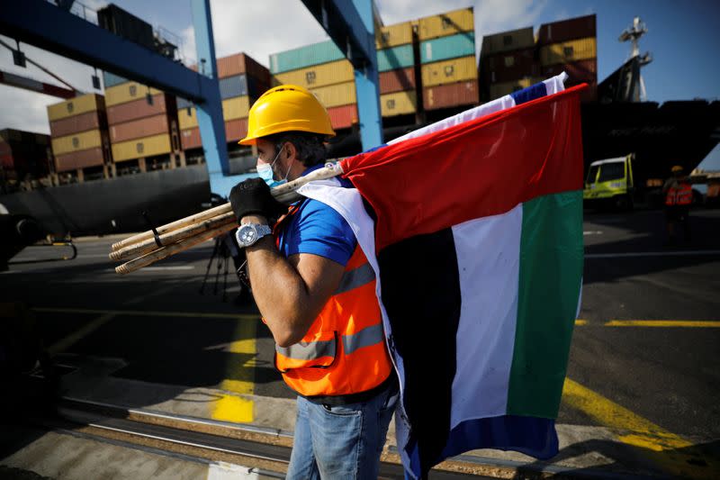 Worker carries Israeli and Emirati flags at Haifa's port