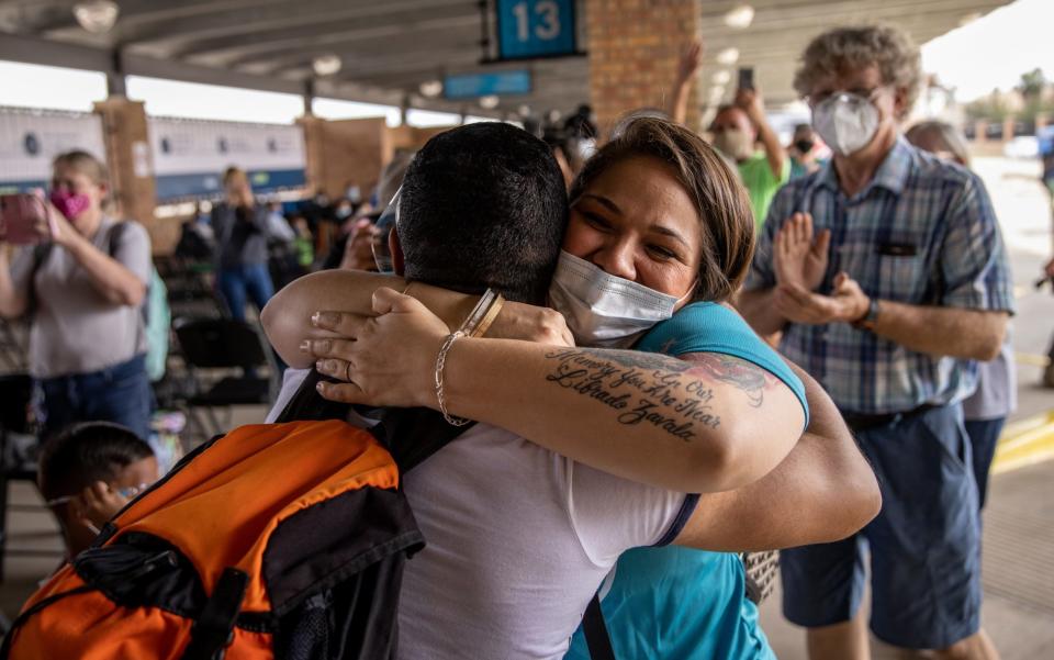 A volunteer (R) welcomes a member of a group of asylum seekers allowed to cross from a migrant camp in Mexico into the US in February - John Moore /Getty Images North America 