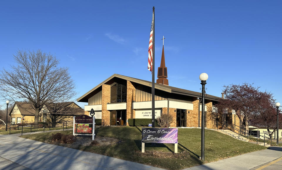 St. John the Baptist Catholic Church sits empty Monday, Dec. 11, 2023, ahead of a wake for one of its members while crime scene tape still surrounds the rectory next door where the Rev. Stephen Gutgsell was fatally stabbed Sunday. (AP Photo/Josh Funk)