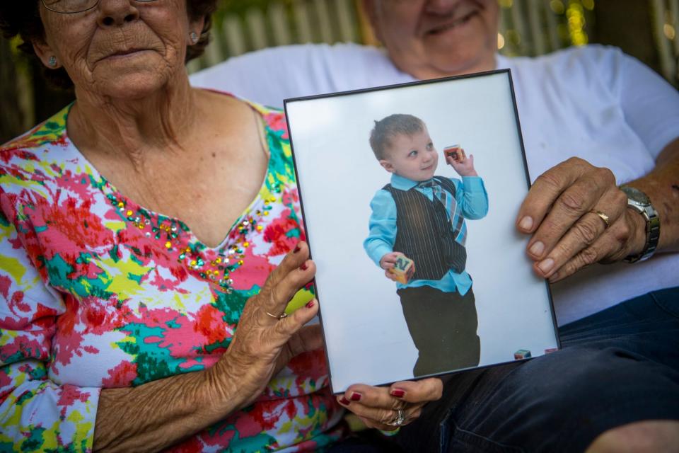 Mary and Oliver Craft hold a picture of Tyler on his favorite swing in their backyard on Tuesday, July 11, 2023. 