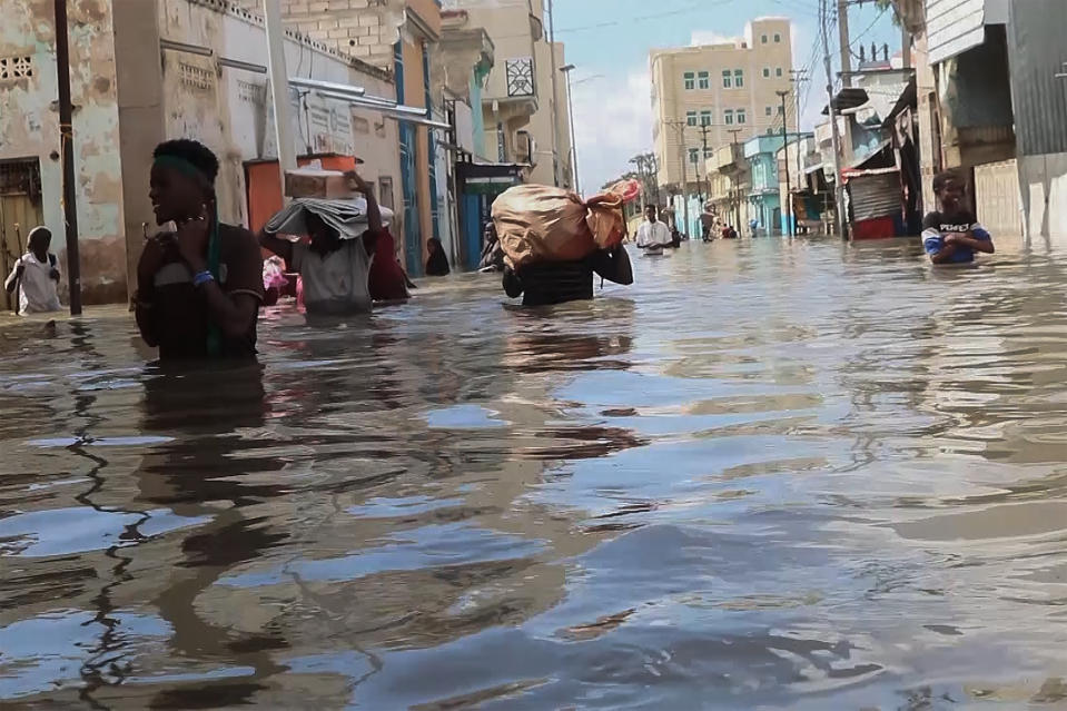 In this image made from video, men walk through floodwaters on a street in the town of Beledweyne, in Somalia, Sunday, Nov. 19, 2023. First, some families fled drought and violence. Now they say they have nowhere to hide from intense flooding as rainfall exacerbated by the weather phenomenon El Nino pummels large parts of Somalia. (AP Photo)