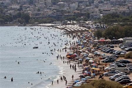 Tourists enjoy the hot weather at Vari beach, some 30 km (19 miles) southeast of Athens July 21, 2013. REUTERS/Yannis Behrakis