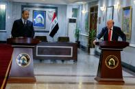 Iraqi Foreign Minister Fouad Hussein speaks with Iraqi Culture Minister Hassan Nadhim during a news conference at the Ministry of Foreign Affairs in Baghdad